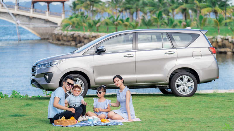 một gia đình bên cạnh xe Innova Venturer 2022 màu đồng